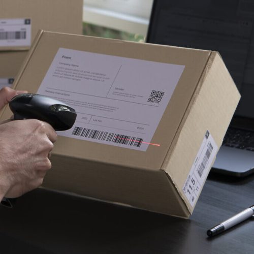 Asian man business owner scanning barcode on delivery parcel. E-commerce male business owner working in factory warehouse.